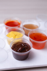 saucers with different types of sauce on a white background