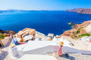 Young woman in Oia village - obrazy, fototapety, plakaty