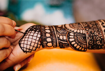 A mehandi design on female hand .Close up image view from top.