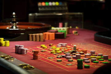 There is a red table with roulette chips in the casino