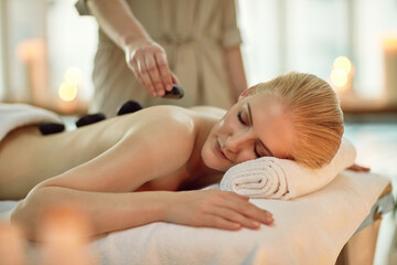 Its where time stands still. Cropped shot of a young woman enjoying a hot stone massage at a spa.