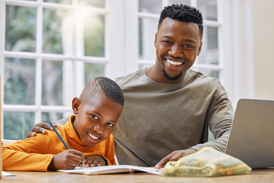 A fathers guidance will take you far. Shot of a young father helping his son with homework at home.
