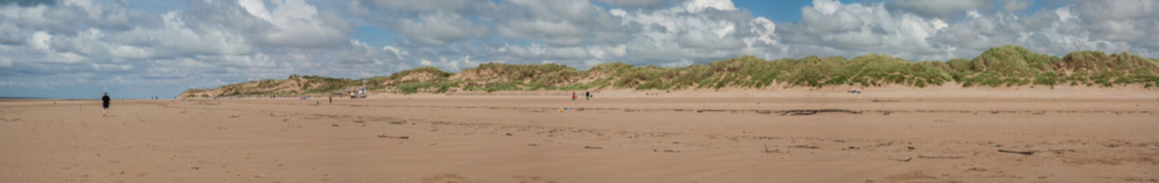 Extensive panorama of Formby Beach, near Liverpool in Northwest England, on a summer day. The panorama is taken from the shoreline, looking towards the sand dunes.