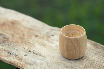 selective focus, bamboo coffee cup, beautiful shape, placed on a wooden balcony The natural background has space for text.