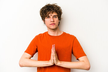 Young caucasian man isolated on white background praying, showing devotion, religious person...