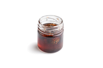 Pine cone jam in glass jar isolated on white, side view, close up.