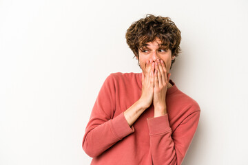 Young caucasian man isolated on white background laughing about something, covering mouth with hands.