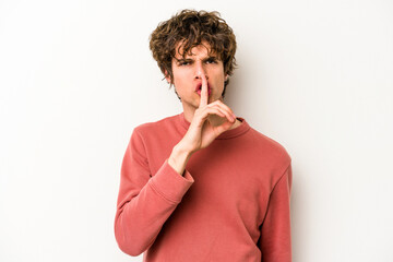 Young caucasian man isolated on white background keeping a secret or asking for silence.
