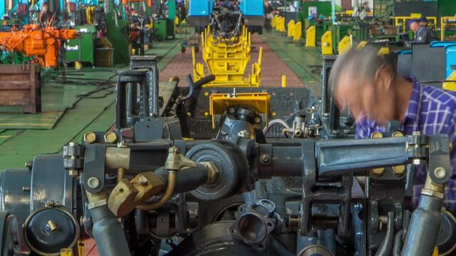 Conveyor assembly stage the body of tractor at big industrial factory timelapse