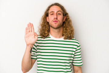 Young caucasian man isolated on white background standing with outstretched hand showing stop sign, preventing you.