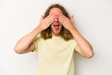 Young caucasian man isolated on white background covers eyes with hands, smiles broadly waiting for a surprise.