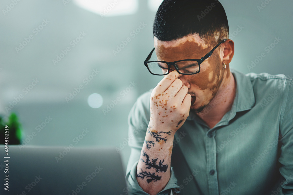 Poster praying that i get through this day. shot of a young businessman struggling with.a headache in an of