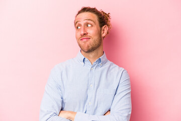 Young caucasian man isolated on pink background dreaming of achieving goals and purposes