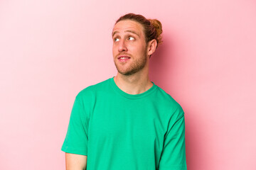 Obraz premium Young caucasian man isolated on pink background relaxed and happy laughing, neck stretched showing teeth.