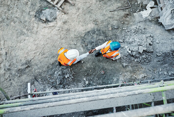 We dont just built properties, we build relationships. Shot of two builders shaking hands at a...