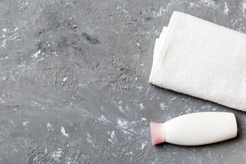 Cosmetic shampoo bottle mockup with towels on a colored table. Bathroom background, toilet accessories for hand and body care