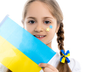 patriotic girl with blue and yellow stars of face holding small ukrainian flag isolated on white.