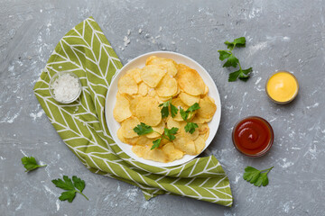 Top view chips with sause in bowl on colored background, top view with copy space