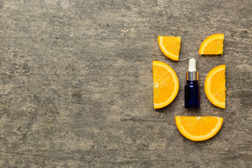 Bottles with orange fruit essential oil on wooden background. alternative medicine top view with copy space