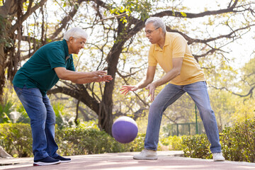 Two senior men having fun playing with ball at park