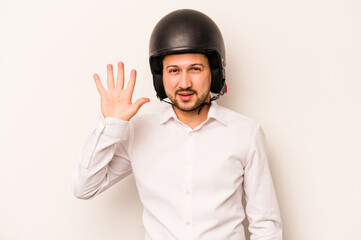 Hispanic business man going to work with motorcycle isolated on white background smiling cheerful showing number five with fingers.