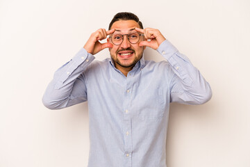 Young hispanic man isolated on white background keeping eyes opened to find a success opportunity.