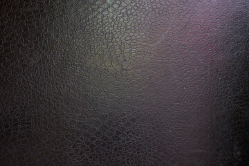 black leather background with pink and green highlight