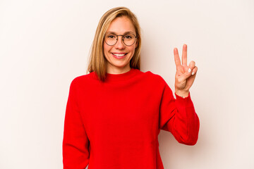 Young caucasian woman isolated on white background joyful and carefree showing a peace symbol with...