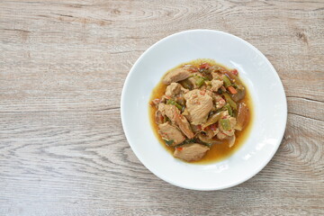 spicy stir fried chicken with slice chili and basil leaf on plate