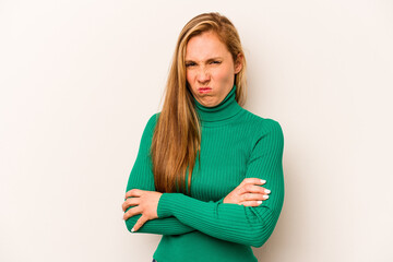 Young caucasian woman isolated on white background frowning face in displeasure, keeps arms folded.
