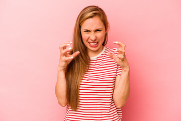 Young caucasian woman isolated on pink background upset screaming with tense hands.