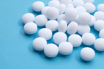 Naphthalene mothballs on blue backgrond.