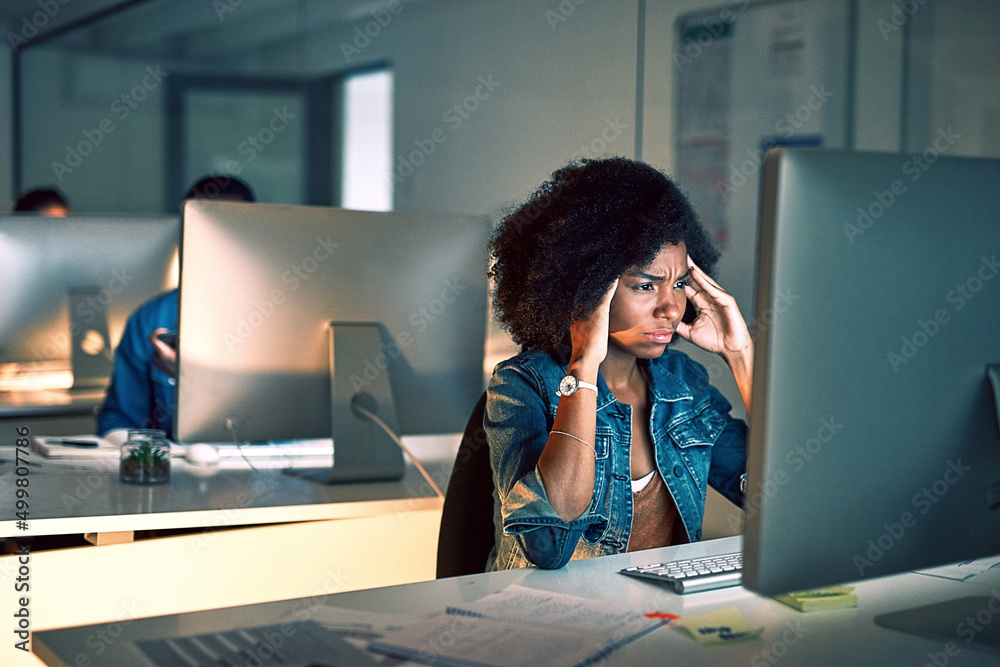 Aufkleber working late has given me such a headache. shot of a young businesswoman looking stressed out while 