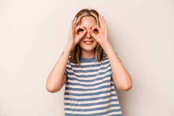 Young caucasian woman isolated on white background excited keeping ok gesture on eye.