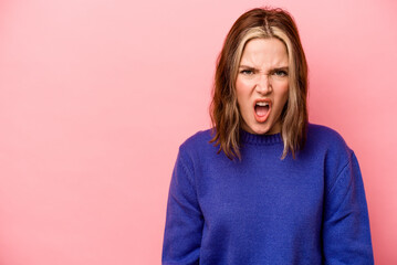 Fototapeta premium Young caucasian woman isolated on pink background shouting very angry, rage concept, frustrated.