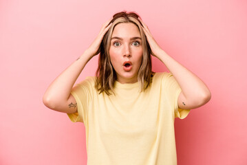 Young caucasian woman isolated on pink background being shocked, she has remembered important...