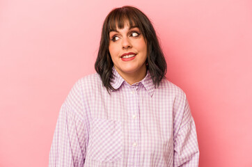 Fototapeta premium Young caucasian woman isolated on pink background laughs and closes eyes, feels relaxed and happy.