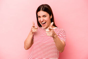 Young caucasian woman isolated on pink background cheerful smiles pointing to front.