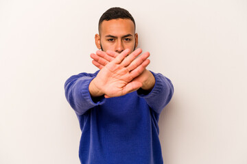 Young hispanic man isolated on white background doing a denial gesture