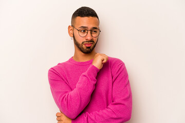 Obraz premium Young hispanic man isolated on white background confused, feels doubtful and unsure.