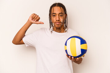 Young African American man playing volleyball isolated on white background feels proud and self...