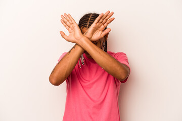 Young African American man isolated on white background keeping two arms crossed, denial concept.