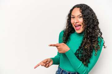 Young hispanic woman isolated on white background pointing with forefingers to a copy space, expressing excitement and desire.