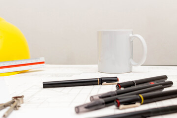 Mockup of architectural concept, Drawing tool and coffee on drawing of blueprint with safety helmet