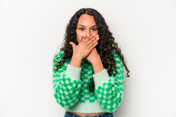Young hispanic woman isolated on white background covering mouth with hands looking worried.