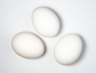 Three eggs on a white background. Cooking. Breakfast preparation. Healthy diet.