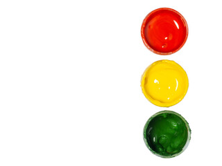 Jars with yellow, green and red paint on a white background. Banks of gouache. Bright background. Traffic lights.  Artist's workshop.