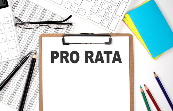 Clipboard with text PRO RATA and keyboard and chart on white background.