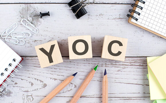 YOC word written on the wood block with chart, glasses and pencils