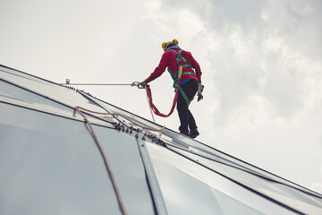 Male workers rope access height safety connecting with eight knots safety harness construction site...